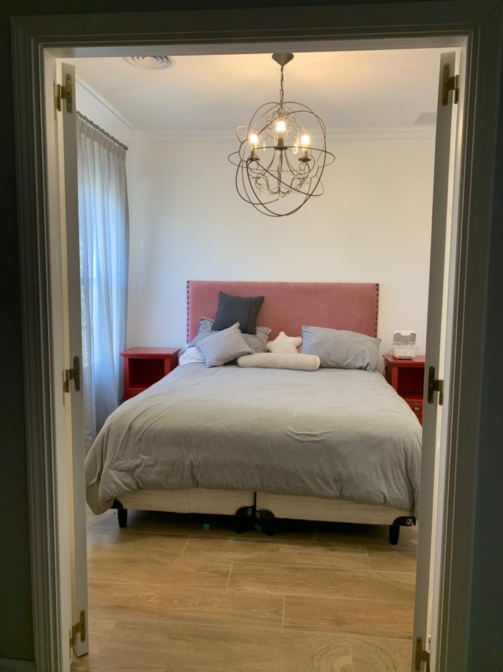 Quarto moderno com cama grande e lustre esférico — projeto La Lomada, por Arcucci Arquitectura, em H5CM+WM